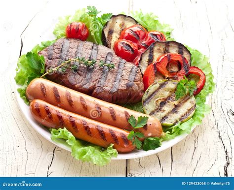 Carne E Vegetais Grelhados Sobre As Folhas Verdes Na Placa Branca Sobre