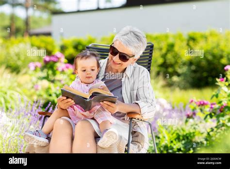 Grandmother And Baby Granddaughter Reading Book Stock Photo Alamy