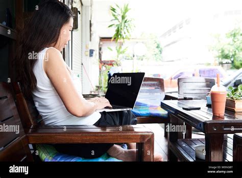 Senior Brunette Business Lady Working With Her Laptop Outside Of The Office Surrounded By Plants