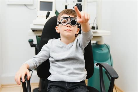 Premium Photo Cheerful Child Boy In Glasses Checks Eye Vision