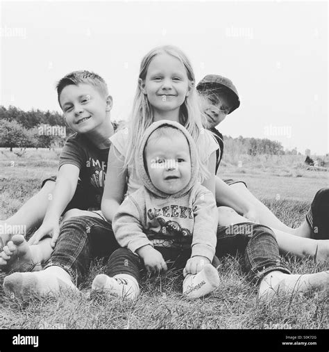 Four siblings ages 8 months to 12 years are posing and smiling for a ...