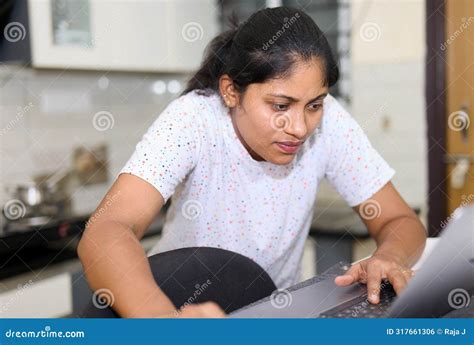 Indian Woman Working On Laptop Computer At Home In The Living Room