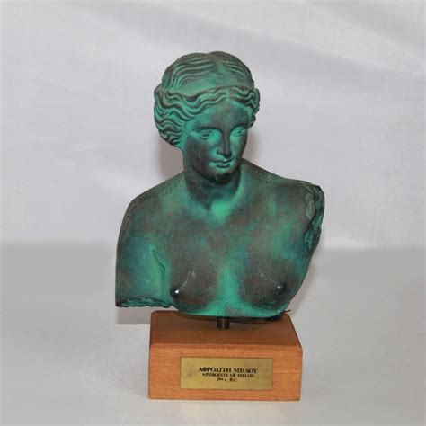 A Bronze Statue Of A Woman S Head On A Wooden Base