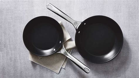 Two Black Pans Sitting On Top Of A Table