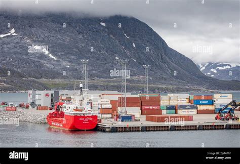 Containers Stacked Up At The Port In Nuuk With Snow Capped Mountains In