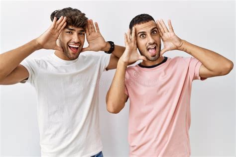 Joven Pareja Gay Parado En Un Contexto Aislado Sonriendo Alegre Jugando Peek Un Boo Con Las