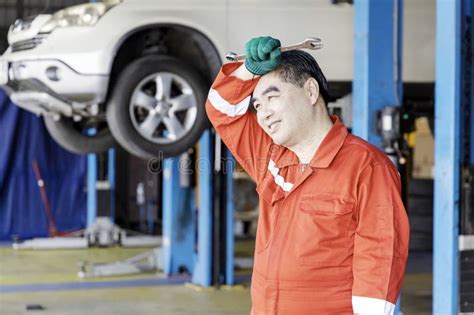 Hot And Tired Man Professional Mechanic Repairs Car In Garage Stock Photo Image Of Maintain