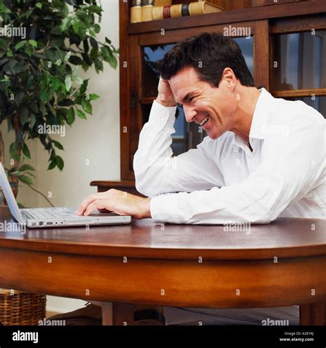 Side Profile Of A Mature Man Using A Laptop And Smiling Stock Photo Alamy