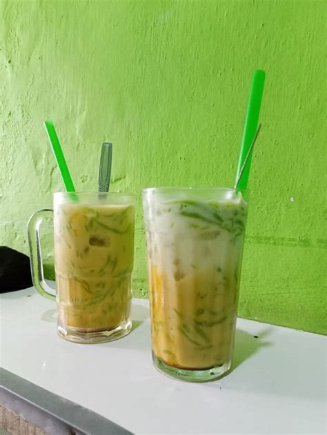 Two Drinks Sitting On Top Of A Counter Next To Each Other With Green