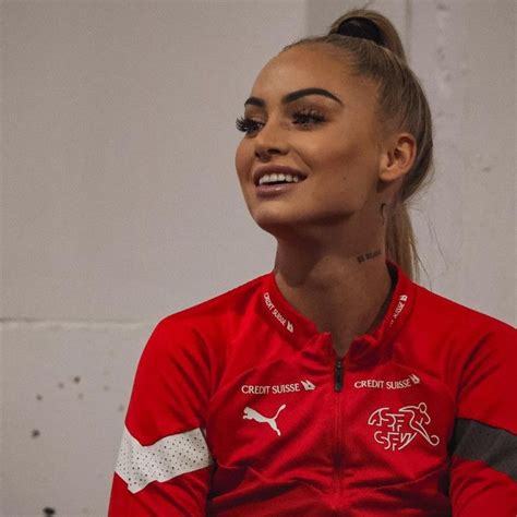 A Woman Sitting Down Wearing A Red Shirt And Black Eyeliners With Her