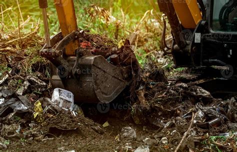 Backhoe digging soil at construction site. Bucket of backhoe digging ...