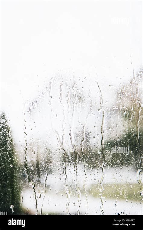 Rain drops dripping on the window glass. Liquid texture. View from ...