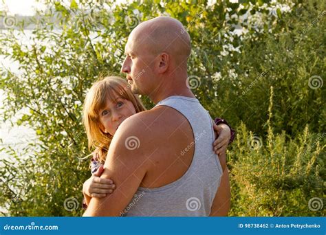 Father Carrying Daughter In His Hands Protecting Her Stock Photo