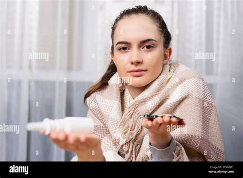 Primer retrato de una mujer enferma con píldoras y aerosol nasal en las