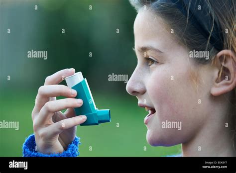 Girl Using Inhaler To Treat Asthma Attack Stock Photo - Alamy