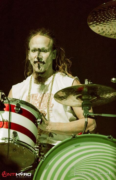 A Man With Long Hair Playing Drums On Stage