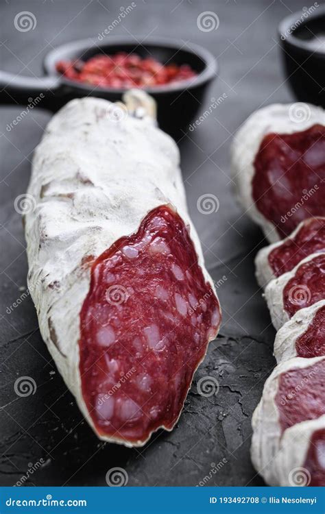 Dry Cured Salchichon Sausage Slices With Herbs On Balck Background