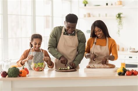 Premium Photo | Happy african family cooking cutting vegetables and ...