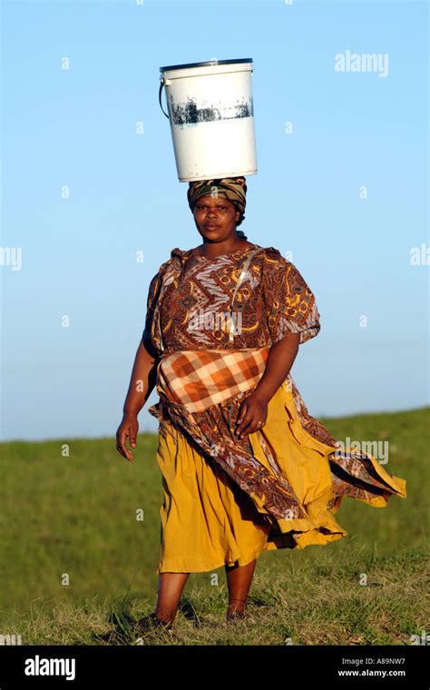 A Xhosa Woman Carrying A Bucket Of Water On Her Head In The Eastern Cape Province Of South