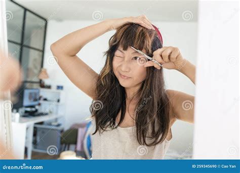 Close Up Of A Young Beautiful Asian Woman Looking At A Mirror And Use A