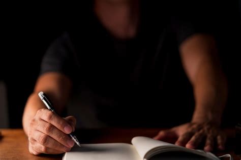 Premium Photo Midsection Of Man Writing In Book At Table