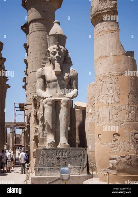 One of two seated statues of Rameses II guard the huge pylon to the ...