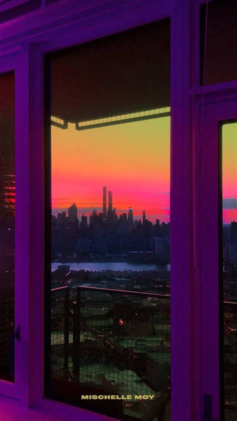 The Sun Is Setting Over A City Skyline From An Apartment Window In New