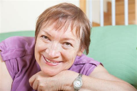 Mature Woman Sitting On Sofa And Smiling Stock Photo Image Of House Caucasian 61064962