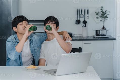 Jovem Casal Gay Bebe Cerveja Enquanto Usa O Laptop Do Computador Em Uma Casa Moderna Homens