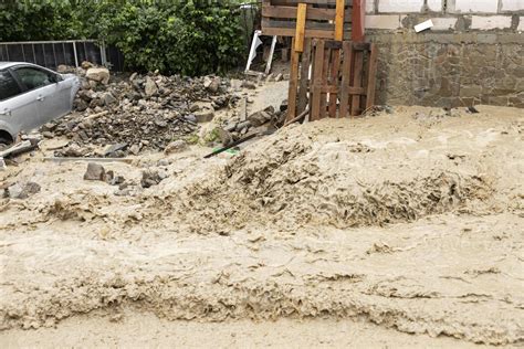 A natural disaster of flooding, muddy streams of water with stones and