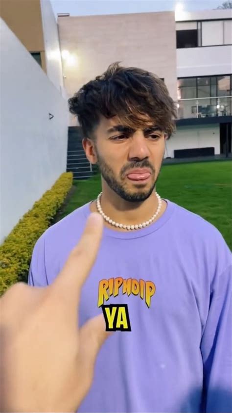 A Man In A Purple Shirt Pointing At The Camera