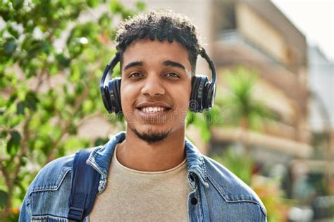 Hispanic Young Man Listening To Music Wearing Headphones At The Street