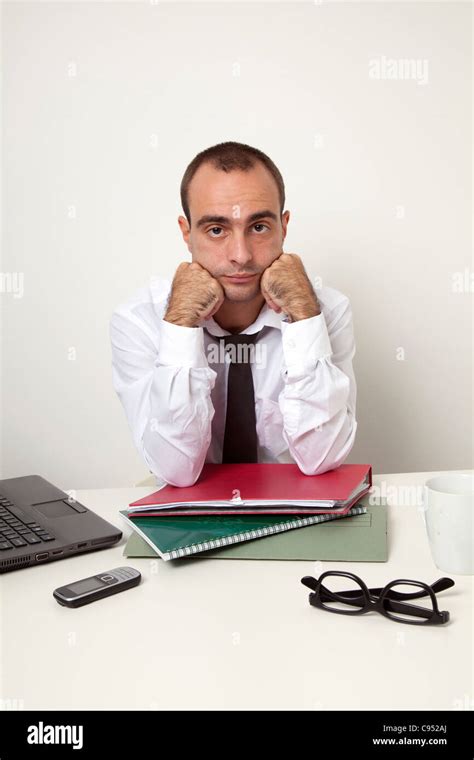 Bored man at work desk Stock Photo - Alamy