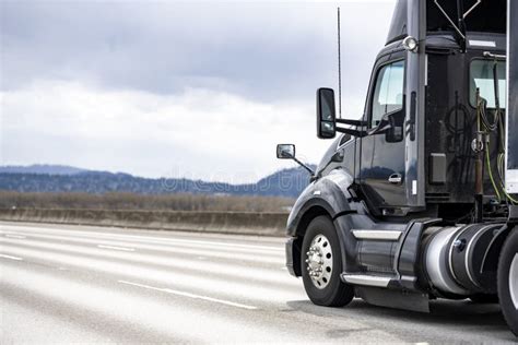 Black Stylish Big Rig Day Cab Semi Truck Tractor Transporting Cargo In Covered Black Semi