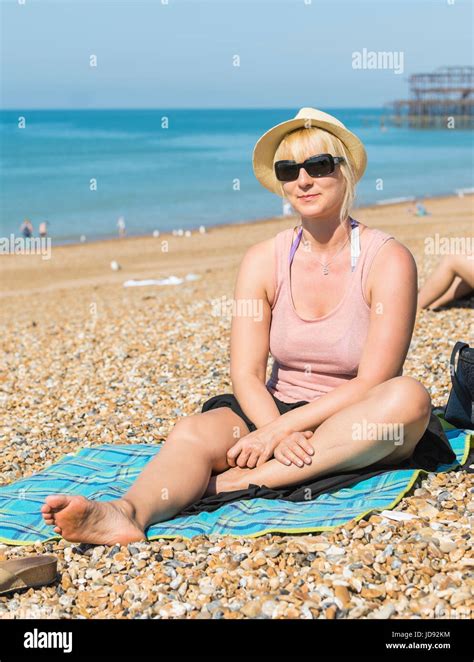 Jolie Jeune Femme Blonde Qui Pose Pour Une Photo Assis Sur Une Plage De Galets Sur Une Chaude