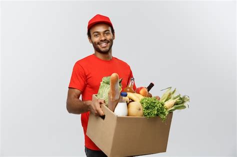 Free Photo | Delivery Concept - Handsome African American delivery man carrying package box of ...