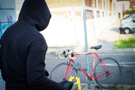 Ladr O Que Rouba Uma Bicicleta Na Rua Da Cidade Imagem De Stock