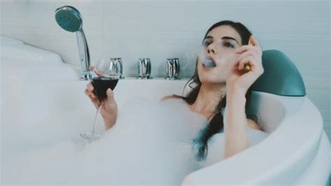 Brunette Girl Taking Bath Full Of Foam Talking On Phone Relax