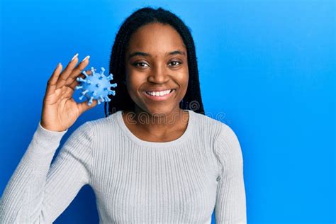 Mujer Afroamericana Con El Pelo Trenzado Sujetando Un Juguete Con Virus