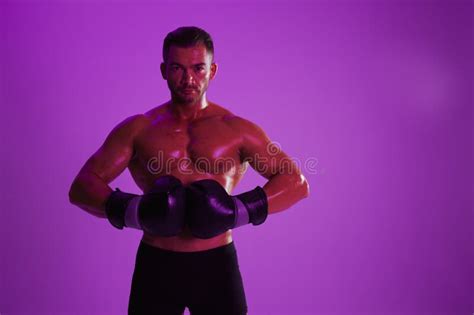 Man Athletic Bodybuilder Poses In Boxing Gloves With Nude Torso Abs In Full Length Background