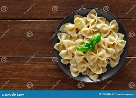 Farfalle Cooked Pasta With Basil Green Leaves On Wooden Brown Plank