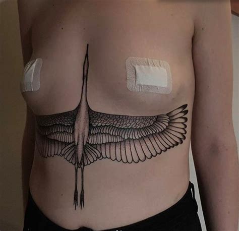 A Woman S Chest With An Angel Wing Tattoo On Her Left Side And White