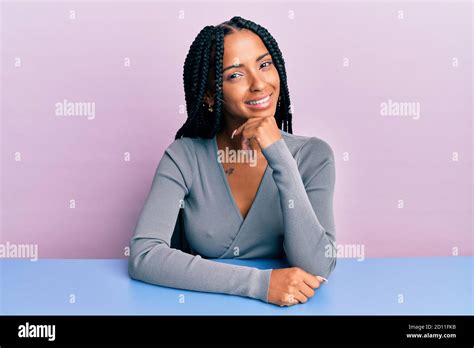 Beautiful Hispanic Woman Wearing Casual Clothes Sitting On The Table