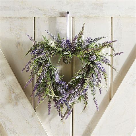 A Heart Shaped Wreath Hanging On The Side Of A Wooden Door With Purple