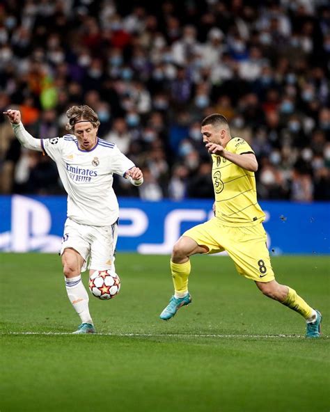 Two Men Playing Soccer On A Field With Fans In The Stands Watching From