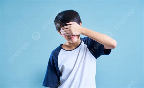 Portrait Of Asian Teenage Boy Covered His Eyes With His Hand In Studio