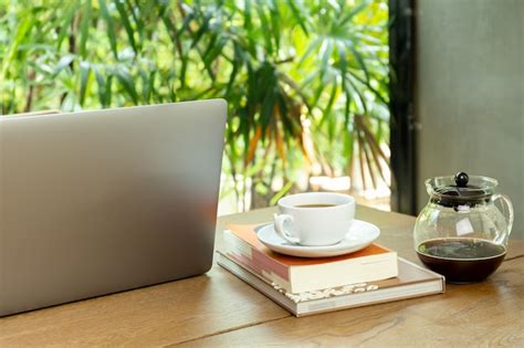 Premium Photo Laptop Computer And Cup Of Coffee With Book On Wooden