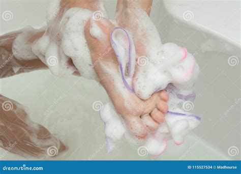 Mom Washes The Childs Feet With A Washcloth And Soap Stock Photo