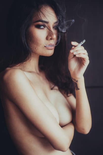 Retrato De Una Mujer Sensual Desnuda Fumando Contra Un Fondo Negro