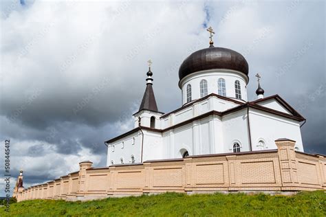 A white brick building is a church church church, a monastery stands behind a brick wall, an ...